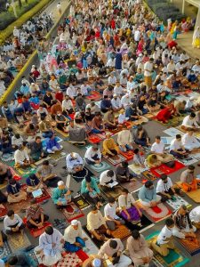 Overhead view of a large group of people praying outdoors in Jakarta, Indonesia.