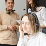Friendly customer support team communicating in a modern office environment, using headsets.
