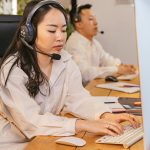Call center professionals focused on tasks with headsets in a modern office setting.